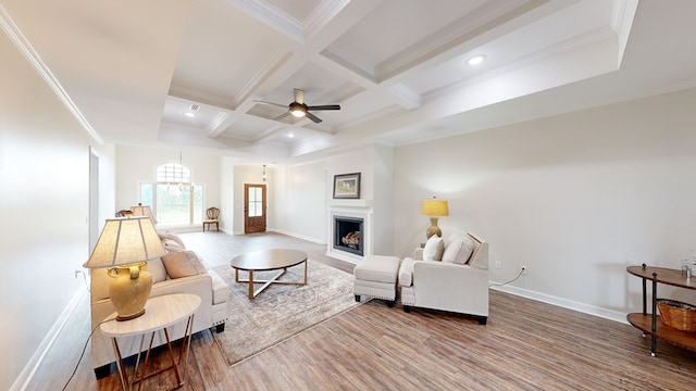 living room featuring beamed ceiling, hardwood / wood-style floors, ornamental molding, and coffered ceiling