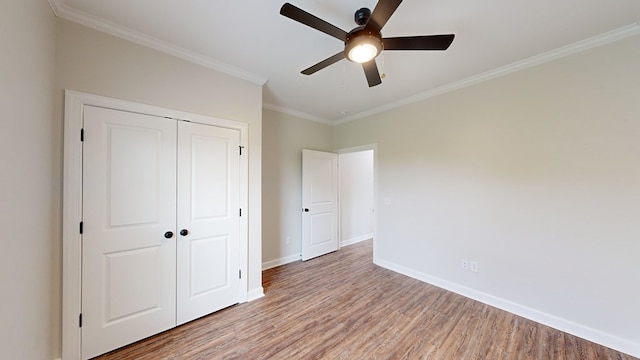 unfurnished bedroom featuring a closet, light hardwood / wood-style floors, ceiling fan, and ornamental molding