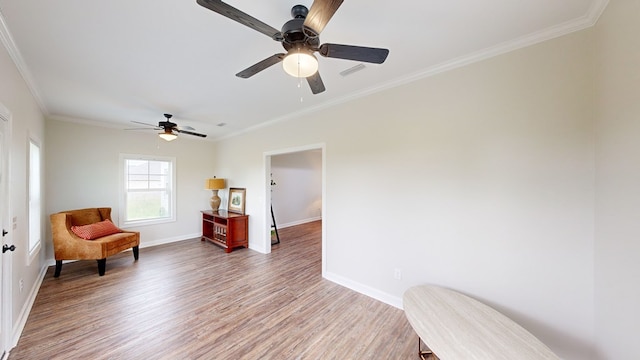 sitting room featuring hardwood / wood-style floors, ceiling fan, and ornamental molding