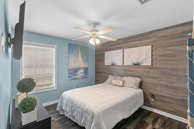 404 Powder Horn Dr, Midland City, AL 36350 - bedroom featuring wood walls, a ceiling fan, dark wood-type flooring, an accent wall, and baseboards