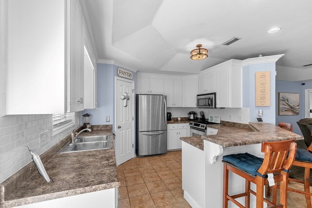 404 Powder Horn Dr, Midland City, AL 36350 - kitchen with stainless steel appliances, a peninsula, a sink, and white cabinetry