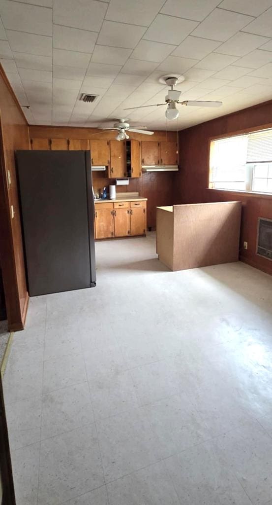 unfurnished living room with a ceiling fan, light floors, and visible vents