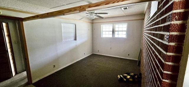 carpeted spare room featuring visible vents, baseboards, and a ceiling fan