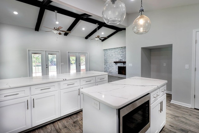 1272 Otho Rd, Abbeville, AL 36310 - kitchen featuring a ceiling fan, stainless steel microwave, french doors, a kitchen island, and wood finished floors