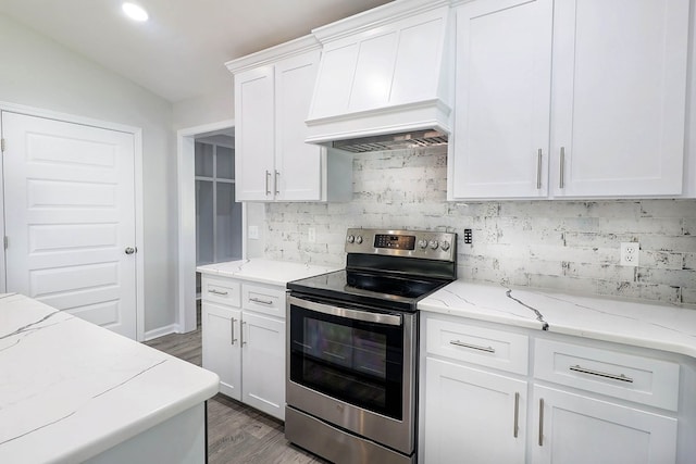 1272 Otho Rd, Abbeville, AL 36310 - kitchen with stainless steel range with electric stovetop, custom exhaust hood, backsplash, white cabinetry, and wood finished floors