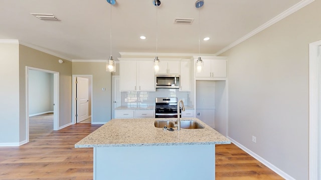kitchen featuring stainless steel appliances, visible vents, white cabinetry, and a sink