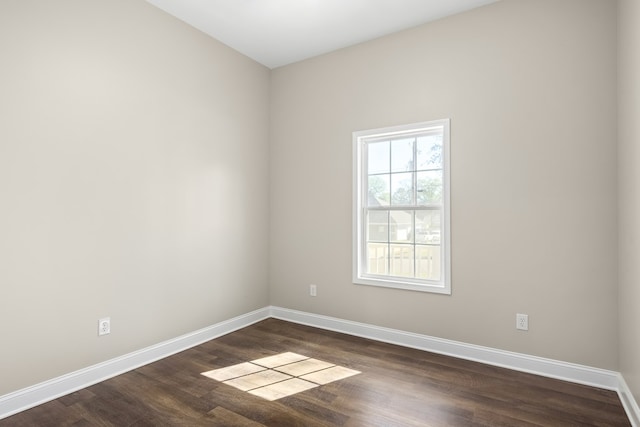 empty room with dark wood finished floors and baseboards