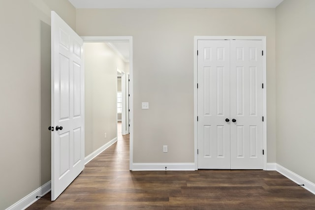 unfurnished bedroom featuring dark wood-type flooring and baseboards