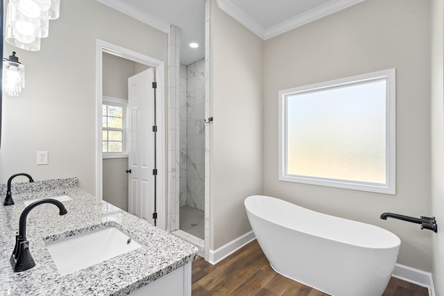 full bathroom with wood finished floors, a sink, a soaking tub, double vanity, and a stall shower