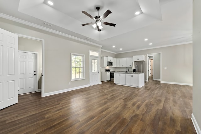 unfurnished living room with baseboards, a raised ceiling, dark wood-style flooring, and ornamental molding