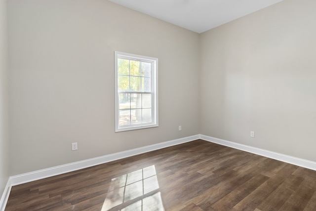 unfurnished room featuring dark wood-style floors and baseboards