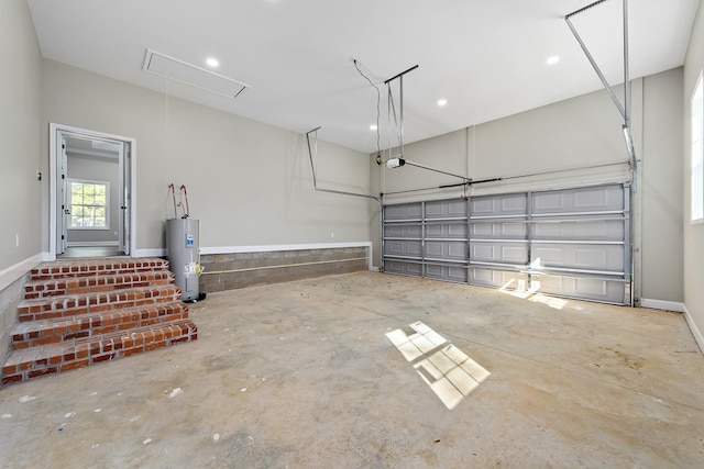 garage featuring baseboards, a garage door opener, and electric water heater