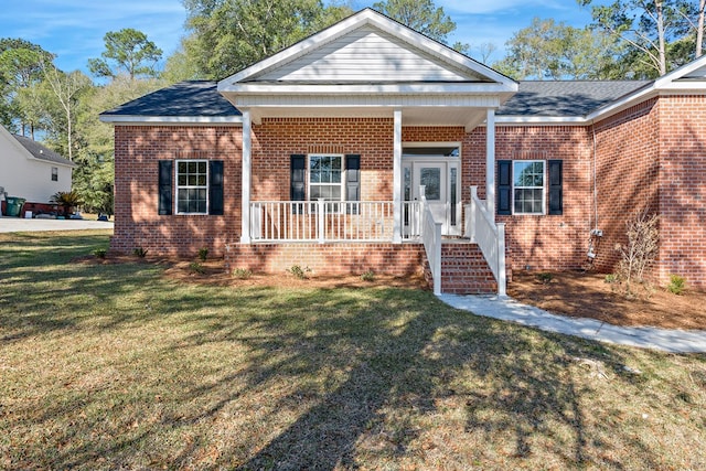 view of front of house featuring covered porch, a front lawn, and brick siding