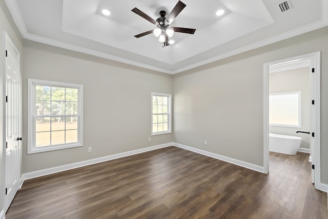 unfurnished bedroom featuring baseboards, a tray ceiling, dark wood-style flooring, and ornamental molding