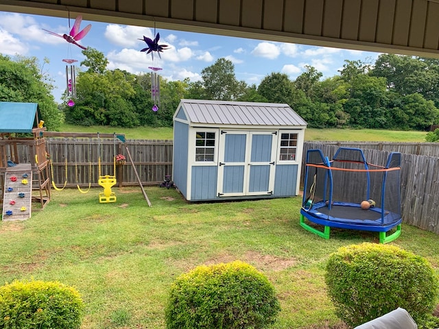 202 Moonlight Ln, Midland City, AL 36350 - fenced backyard featuring a trampoline, a storage unit, and a playground