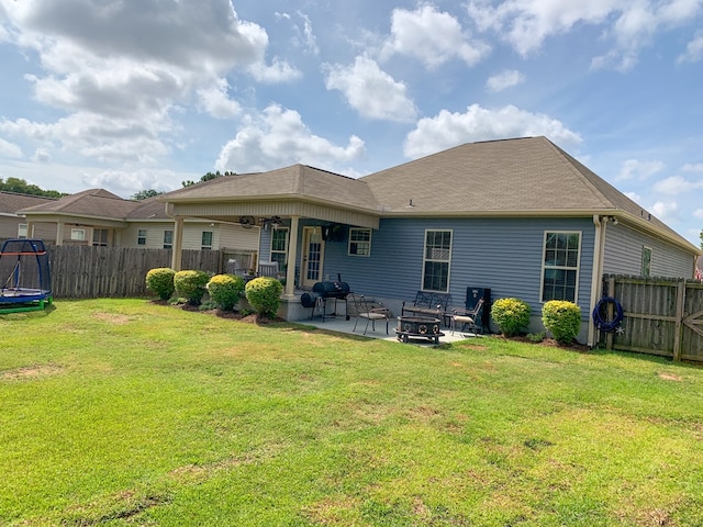 202 Moonlight Ln, Midland City, AL 36350 - rear view of house with a patio, a fire pit, a fenced backyard, and a trampoline