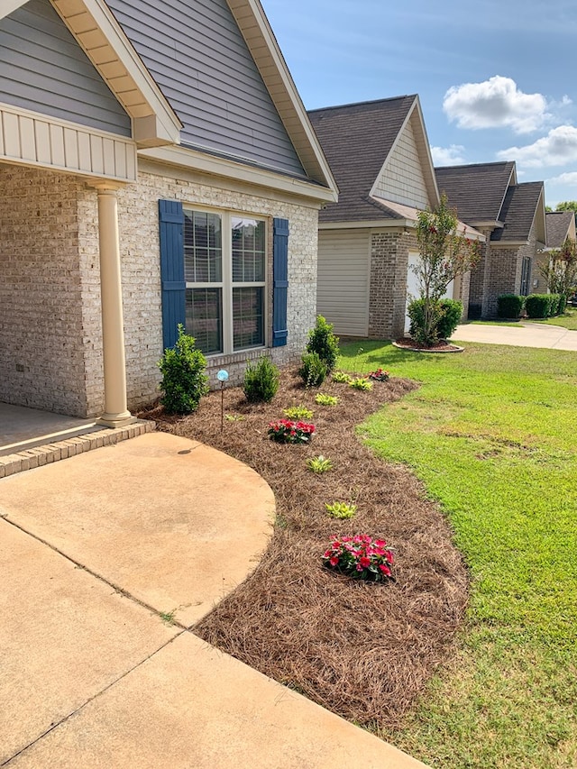 202 Moonlight Ln, Midland City, AL 36350 - view of side of home with brick siding, a lawn, concrete driveway, and a shingled roof
