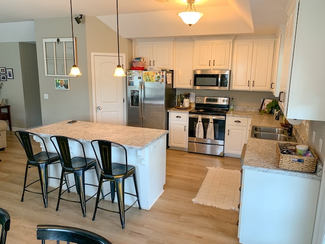 202 Moonlight Ln, Midland City, AL 36350 - kitchen featuring stainless steel appliances, light wood-style floors, white cabinets, and a kitchen breakfast bar