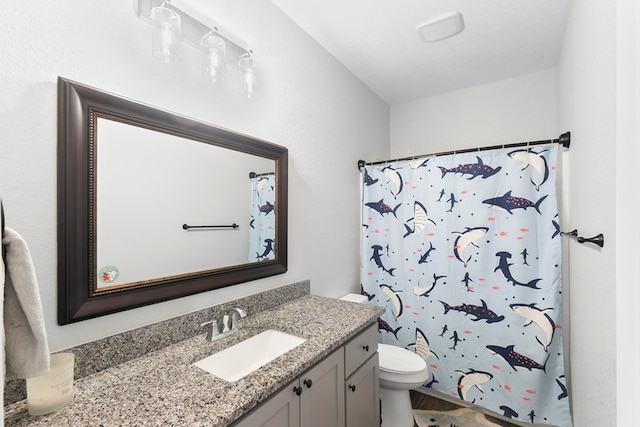 full bathroom featuring curtained shower, vanity, and toilet