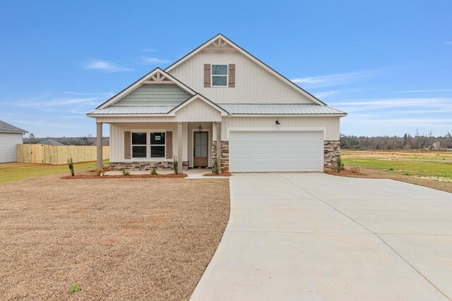 view of front facade with a porch, a front yard, and a garage