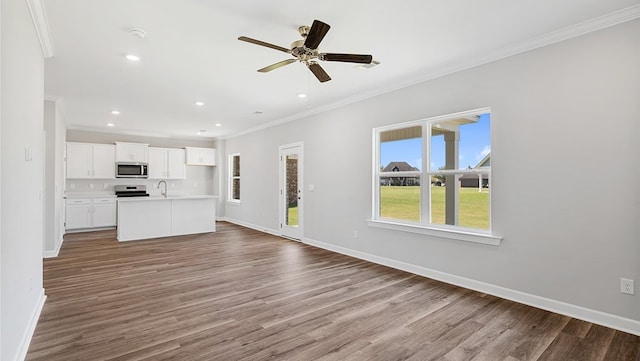 unfurnished living room featuring crown molding, hardwood / wood-style floors, ceiling fan, and sink