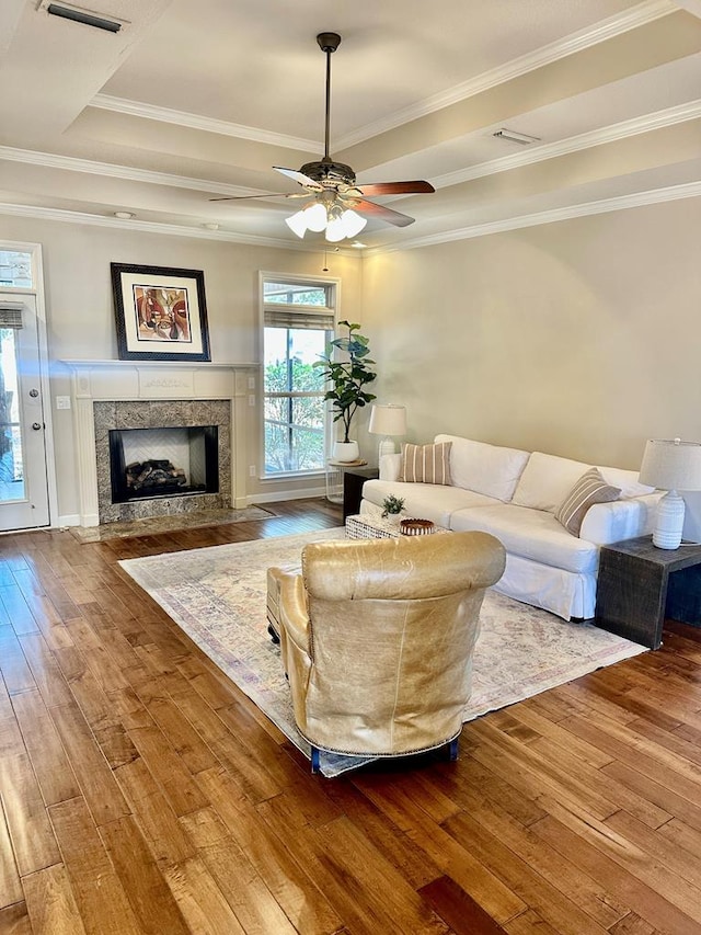 living room featuring ornamental molding, a premium fireplace, and hardwood / wood-style flooring