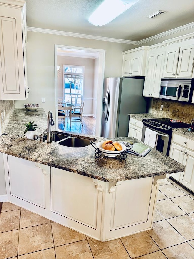 kitchen featuring stainless steel appliances, white cabinetry, sink, and stone counters