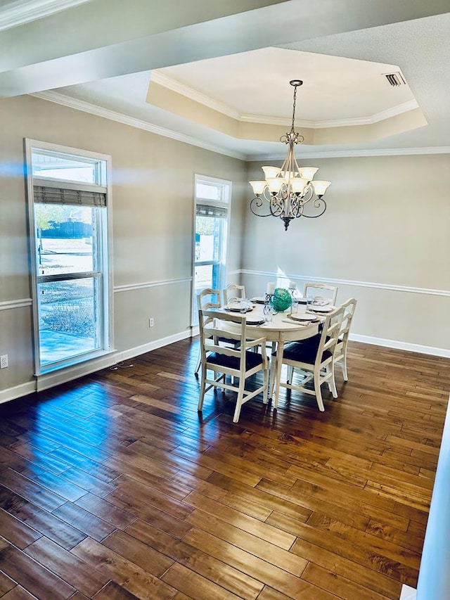 dining room with a chandelier, crown molding, dark hardwood / wood-style floors, and a tray ceiling