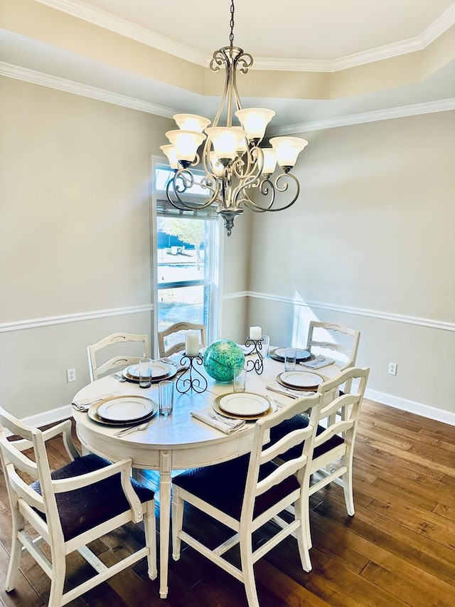 dining room with a notable chandelier, crown molding, and hardwood / wood-style floors