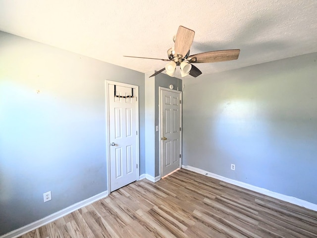 unfurnished bedroom with ceiling fan, a textured ceiling, and hardwood / wood-style flooring