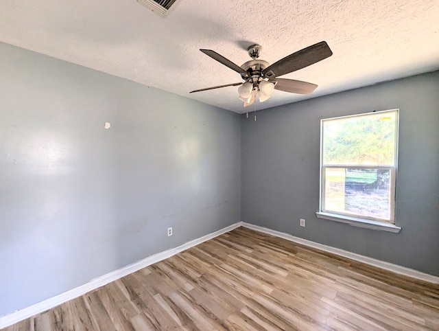 spare room featuring a textured ceiling, light hardwood / wood-style flooring, and ceiling fan