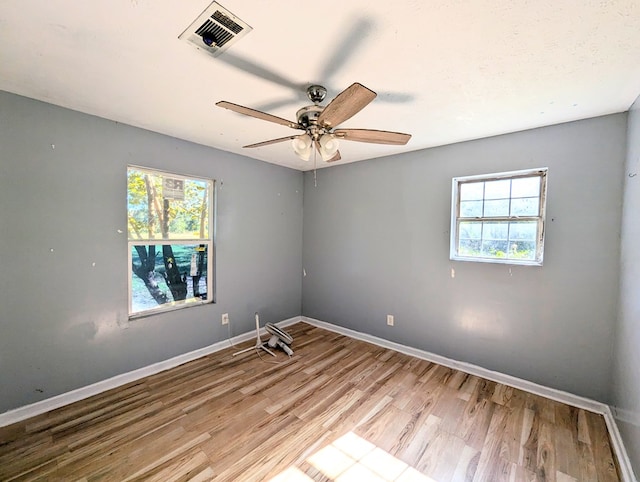 spare room featuring plenty of natural light, ceiling fan, and light hardwood / wood-style flooring