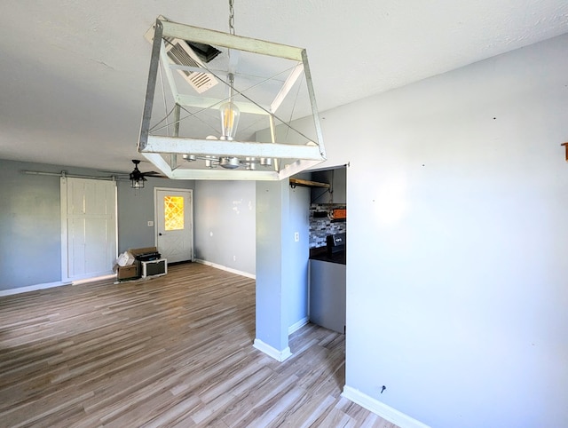 interior space with hardwood / wood-style flooring, ceiling fan, a barn door, and a textured ceiling