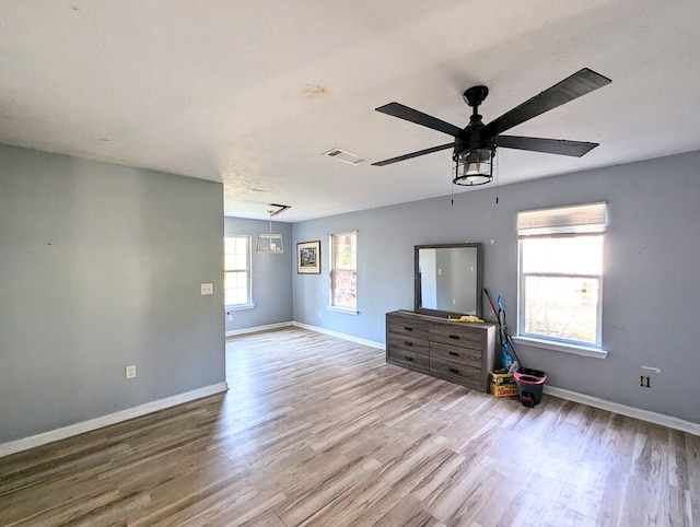 empty room with ceiling fan, light hardwood / wood-style floors, and a textured ceiling