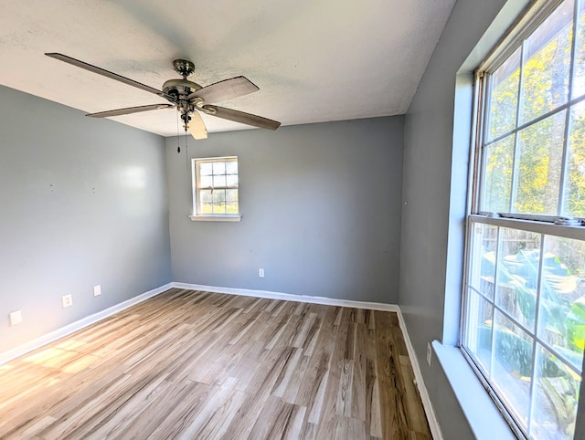 empty room featuring a textured ceiling, light hardwood / wood-style floors, and ceiling fan