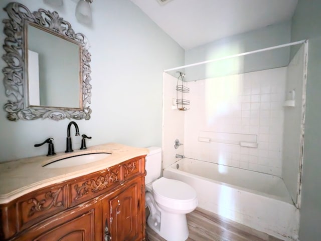 full bathroom featuring hardwood / wood-style floors, vanity, toilet, and tiled shower / bath