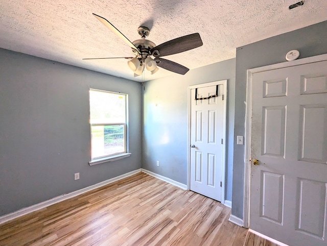 interior space with ceiling fan, light hardwood / wood-style floors, and a textured ceiling