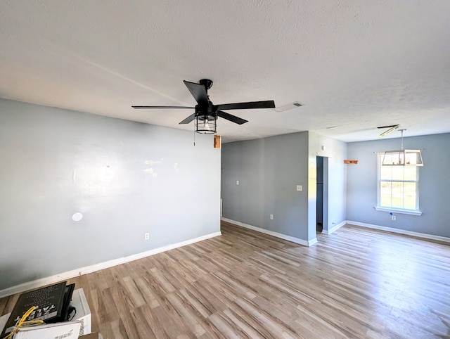 spare room featuring a textured ceiling, light wood-type flooring, and ceiling fan