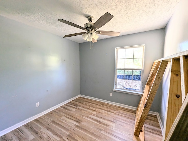 unfurnished bedroom with ceiling fan, light wood-type flooring, and a textured ceiling