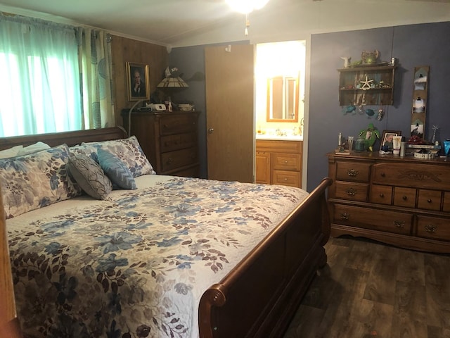 bedroom featuring lofted ceiling, ensuite bath, ornamental molding, and dark wood-style flooring