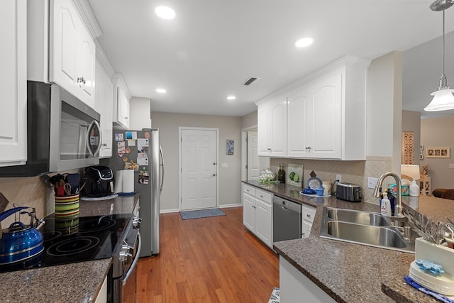 kitchen featuring pendant lighting, decorative backsplash, white cabinetry, appliances with stainless steel finishes, and sink