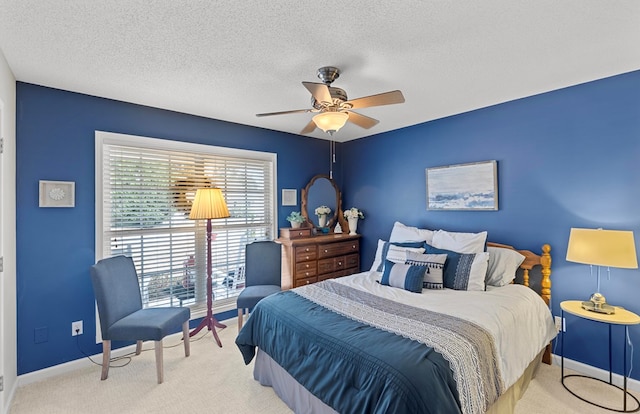 carpeted bedroom featuring ceiling fan and a textured ceiling