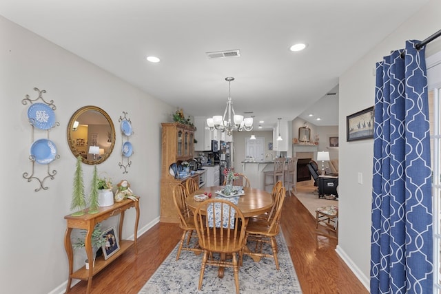 dining room with hardwood / wood-style floors and an inviting chandelier