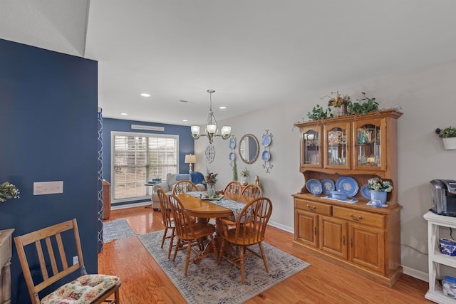 dining room featuring light wood-type flooring and a chandelier