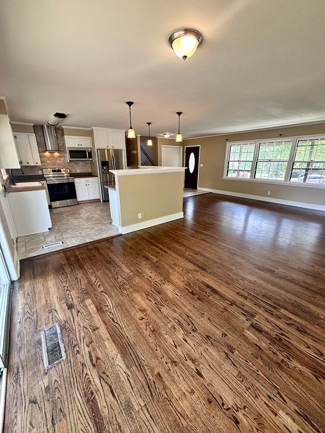 2203 Stonebridge Rd, Dothan, AL 36301 - kitchen with stainless steel appliances, white cabinets, wood finished floors, open floor plan, and decorative backsplash