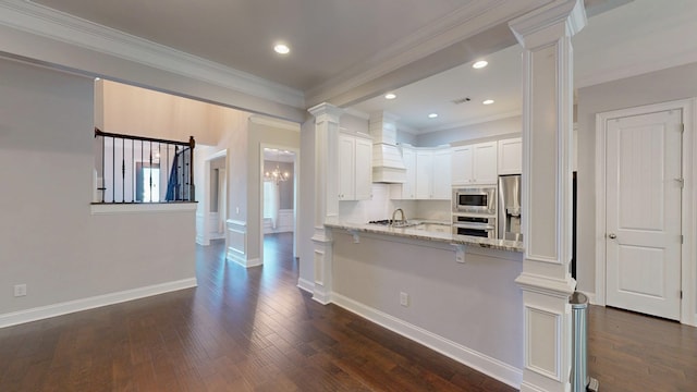 174 Ridgecrest Loop, Dothan, AL 36301 - kitchen featuring appliances with stainless steel finishes, decorative columns, light stone countertops, white cabinetry, and a breakfast bar area
