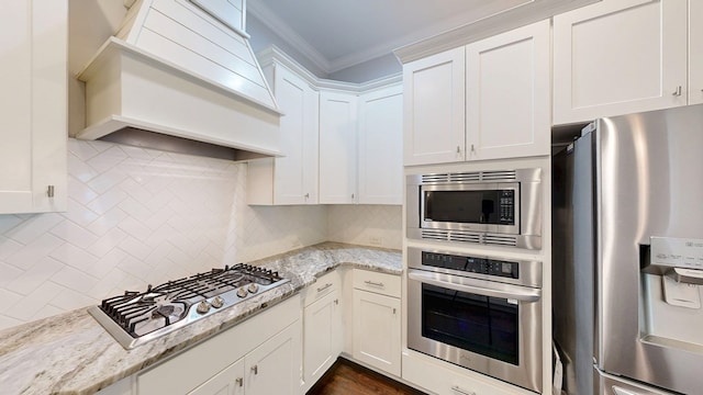 174 Ridgecrest Loop, Dothan, AL 36301 - kitchen with stainless steel appliances, premium range hood, ornamental molding, white cabinetry, and light stone counters