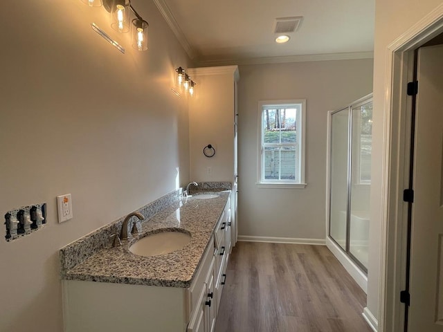 bathroom with crown molding, vanity, a shower with shower door, and hardwood / wood-style floors