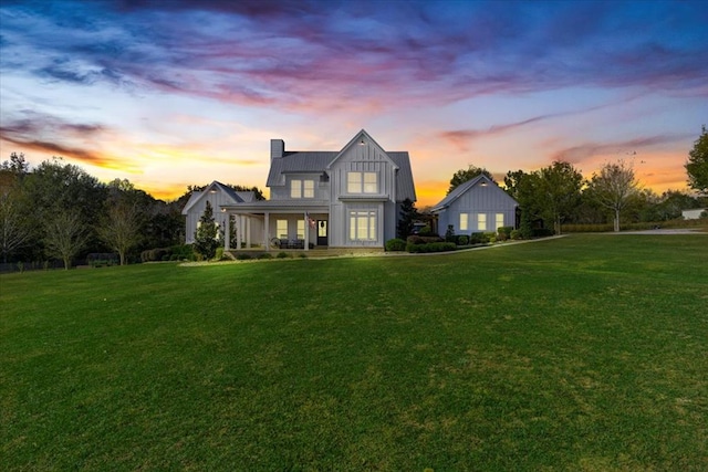 back house at dusk with a yard and a porch