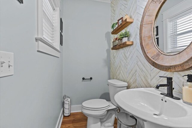 bathroom with hardwood / wood-style flooring, toilet, and sink